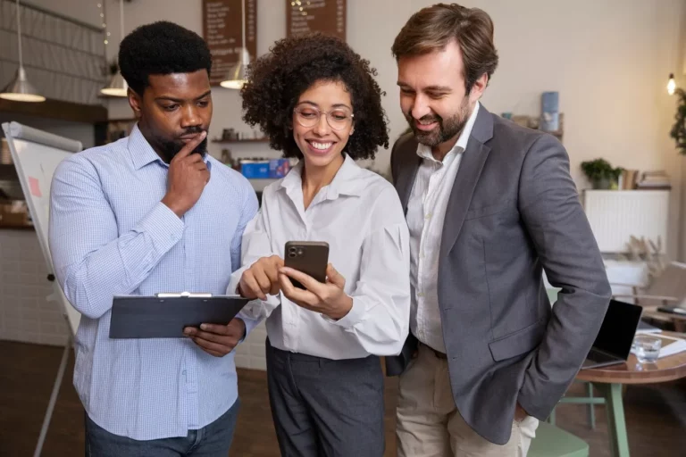 3 pessoas de negocios olhando para smartphone e sorrindo representa sucesso informação de valor mobile