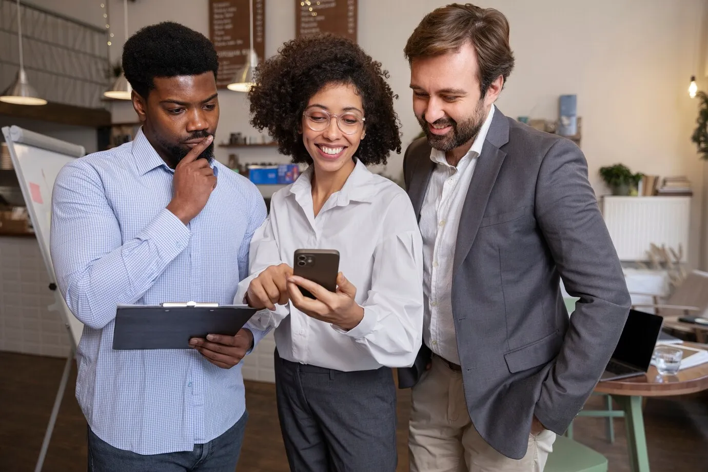 3 pessoas de negocios olhando para smartphone e sorrindo representa sucesso informação de valor mobile