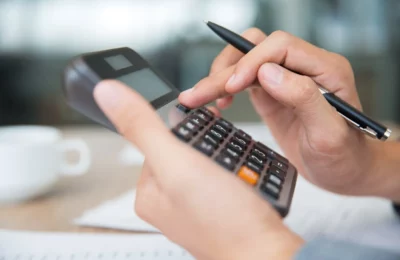 pessoa digitando na calculadora renda fixa e renda variável qual o melhor finanças e investimentos