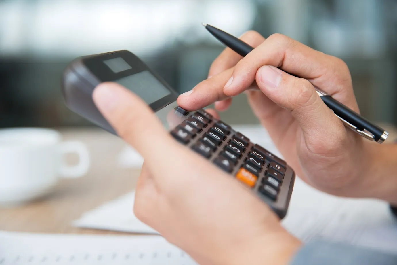 pessoa digitando na calculadora renda fixa e renda variável qual o melhor finanças e investimentos